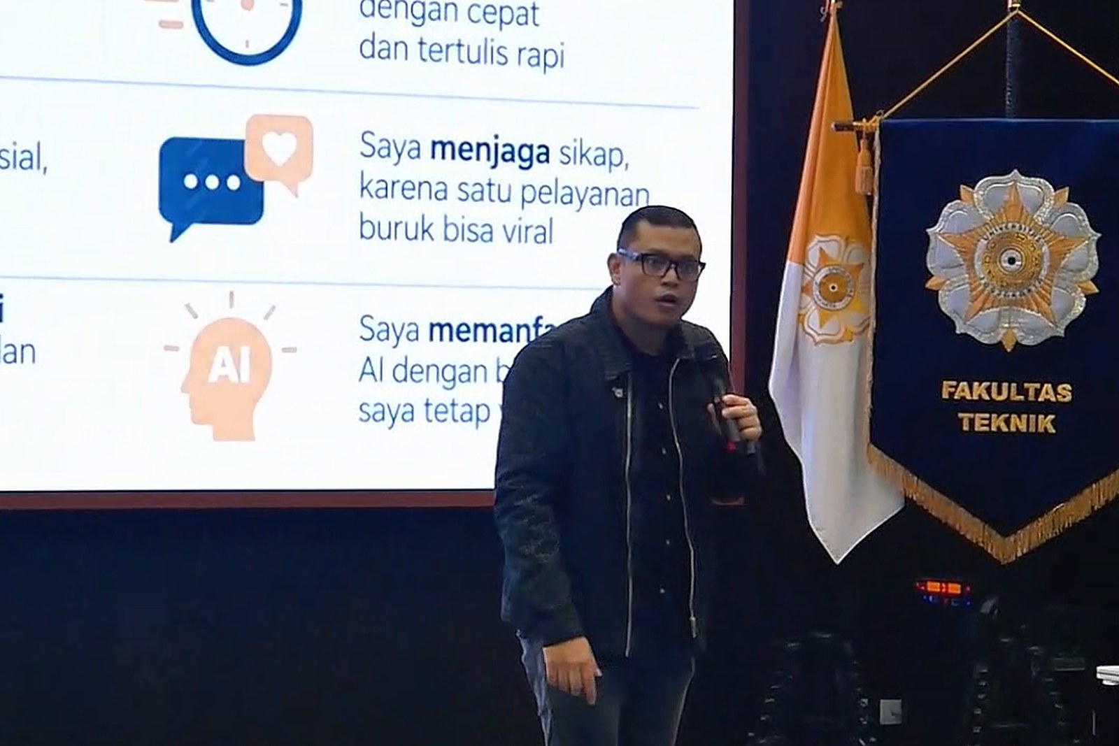 Saya berbicara dengan mikrofon di depan layar yang menampilkan tahap kehumasan 4.0 dan 5.0, di samping panji Fakultas Teknik UGM.